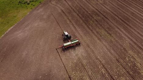 Acending-top-down-shot-of-industrial-tractor-Plowing-Corn-Crop-Field---Agriculture-Machinery