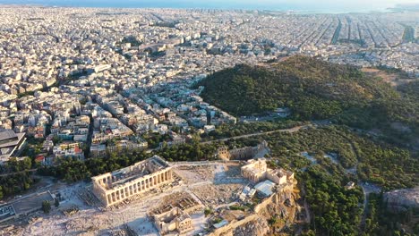 City-center-of-Athens,-residential-buildings,-the-ocean,-aerial-view-at-sunrise-time