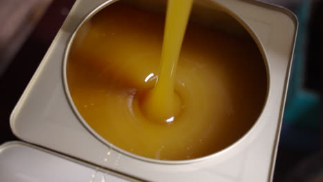 Pouring-Honey-in-tin-canister