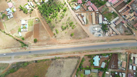 Luftaufnahme-Des-Verkehrs-Auf-Einer-Ruhigen-Straße,-Die-Durch-Eine-Kleine-Stadt-In-Kenia-Führt