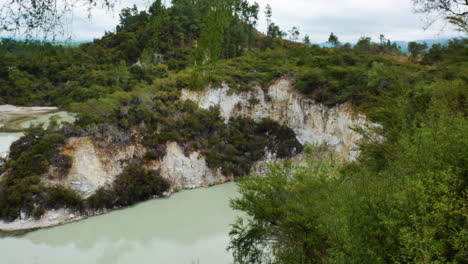Beautiful-mountains-covered-with-green-plants-and-hydrothermal-lake-in-valley