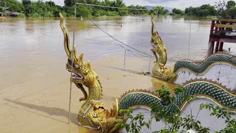 Naga-Drachenskulpturen,-Die-Nach-Heftigen-Regenfällen-Und-Überschwemmungen-In-Thailand-In-überlaufendem-Flusswasser-überschwemmt-Wurden