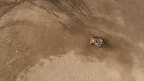 Fast-FPV-drone-dive-to-dirt-bike-motocross-rider-racing-against-quad