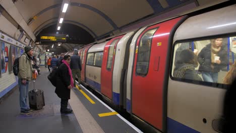 Gente-Entrando-Y-Saliendo-Del-Tren-En-La-Estación-De-Metro-De-Londres-En-Londres,-Reino-Unido