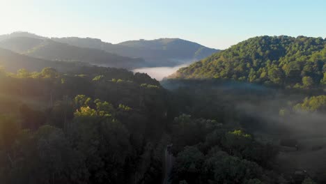 4K-Drone-Video-Flying-Above-Trees-Along-Mountain-Road-in-Smoky-Mountains-near-Asheville,-NC-on-Misty-Morning