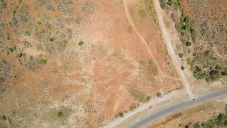 Top-down-aerial-of-dirt-roads-connected-to-a-motorway-in-rural-Africa