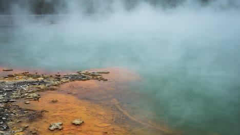 Schöne-Farben-Von-Ufer-Und-See-Mit-Fliegendem-Dampf-über-Der-Oberfläche-Im-Hydrothermalgebiet-Wai-o-tapu,-Nz