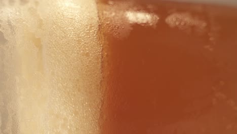 Vertical-Footage-Of-Turntable-Platform-Of-Rotating-Cold-Beer-Pint-In-Glass