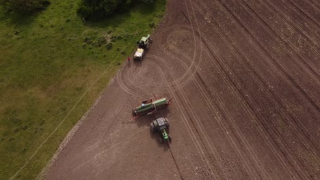 Farmers-repairing-tractor-and-mechanical-plow-on-farm-field