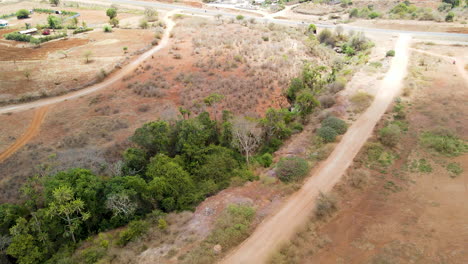 Jib-up-of-dirt-road-in-rural-Kenya,-revealing-a-rural-asphalt-motorway