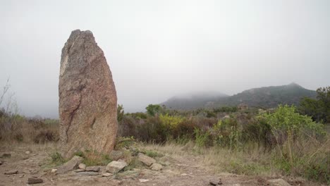 Large-Menhir,-Standing-Stone-With-Foggy-Landscape-In-Background
