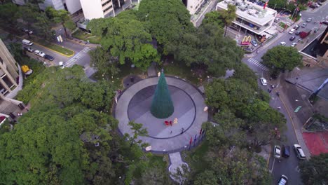 Drone-flying-over-Plaza-Isabel-La-Católica-in-La-Castellana,-then-tilting-to-Caracas,-Venezuela