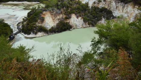 Top-down-shot-of-green-colored-lake-inside-massive-volcanic-crater-at-Wai-o-tapu,NZ
