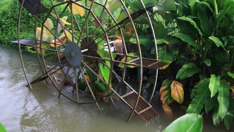 4K-Waterwheel-Spinning-Slowly-with-Wooden-Paddles-and-Metal-Frame-in-Murky-Water