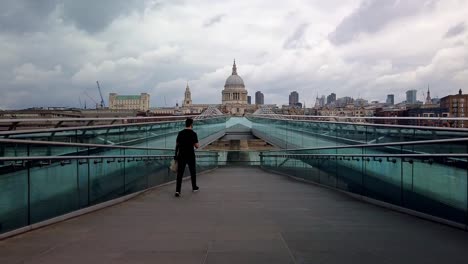 Time-lapse-of-Commuters-and-pedestrians-walking-across-Millennium-Bridge,-London-with-St-Paul's-Cathedral-in-the-background,-early-in-the-morning