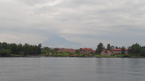 From-shore-of-Lake-Kivu-in-Goma,-Mt-Nyiragongo-volcano-in-distance