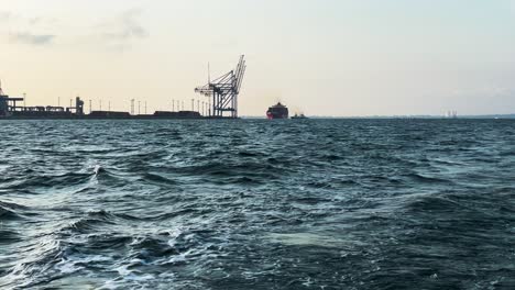 Wavy-Water-Of-Black-Sea-Overlooking-Harbor-Cranes-From-A-Sailing-Boat-In-Odesa,-Ukraine