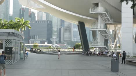 People-relaxing-walking-in-the-public-area-around-marina-bay-infront-of-the-luxury-department-store-under-sunshine-summer-day