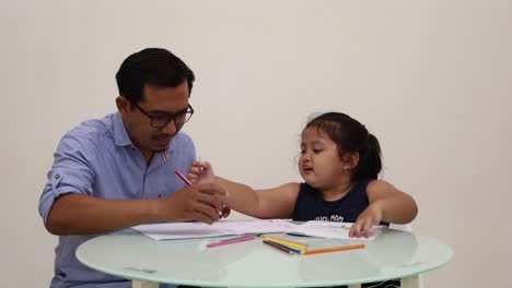 Indonesia---Dec-18,-2022-:-asian-little-girl-studying-to-write-with-his-dad