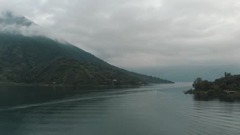 Boats-Sailing-On-Serene-Lake-Of-Atitlan-With-Santiago-Volcano-During-Misty-Sunrise-In-Guatemala