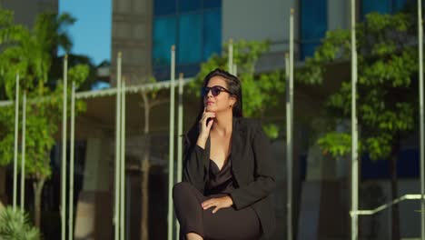 Pretty-fashion-model-sits-in-a-Caribbean-city-on-a-sunny-day-in-business-attire