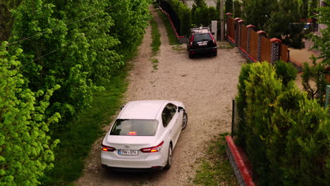 Aerial-Drone-Shot-of-car-Driving-Up-Driveway