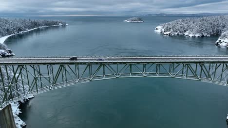 Wide-view-of-a-car-driving-across-Whidbey-Island's-Deception-Pass-bridge-in-the-winter