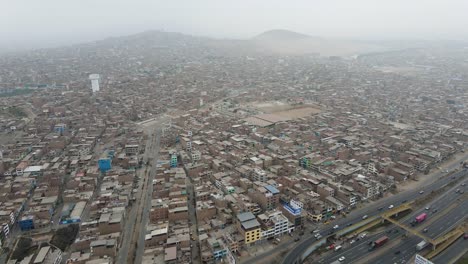 Aerial-shot-of-houses-next-to-a-highway-in-the-crowded-neighborhood-of-Ventanilla