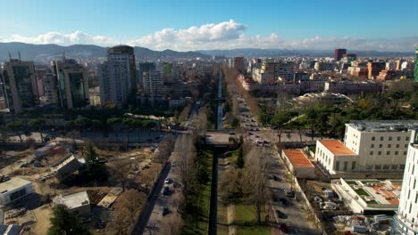 High-towers-and-buildings-under-construction-on-both-sides-of-city-river-in-Tirana,-Albania