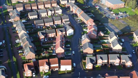 Aerial-view-above-new-build-modern-housing-estate-property-rooftops-England-pan-right
