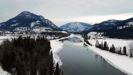 Partially-Frozen-North-Thompson-River-with-Reflections-of-Snow-Covered-Mountains-Captured-in-Little-Fort,-BC:-An-Aerial-View