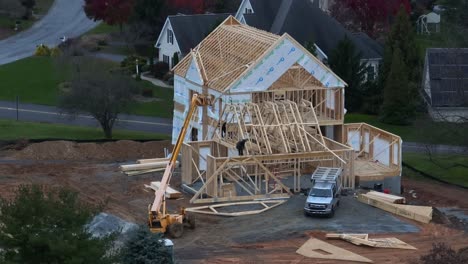 Construction-workers-install-roof-trusses-on-new-home