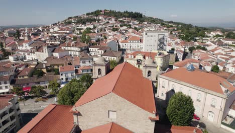 Aerial-top-view-Castelo-Branco-Cathedral-with-cityscape-background,-sunny-day---Portugal
