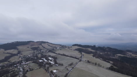 A-flight-over-the-countryside-with-a-path-leading-through-the-trees-and-a-view-of-the-surrounding-thing-during-the-beginning-of-the-snowfall