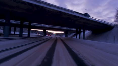 POV-driving-shot-passing-under-a-highway-bridge-in-Helsinki-during-winter