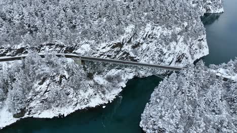 High-up-aerial-view-of-a-bridge-in-Washington-State-covered-in-snow