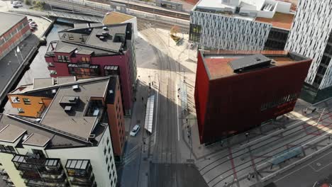 Tramway-stop-near-modern-downtown-buildings-in-Gamlestaden,-Gothenburg,-aerial-drone-view