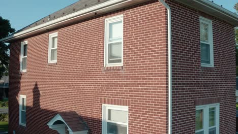 Rising-aerial-establishing-shot-of-red-brick-two-story-home