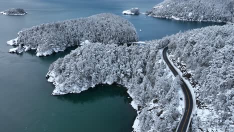 Rising-drone-shot-of-Deception-Pass-State-Park-covered-in-snow
