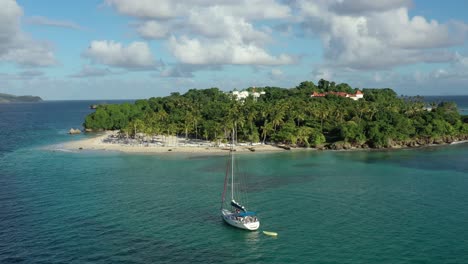 People-on-board-of-anchored-sailboat-on-transparent-seawater-of-Cayo-Levantado,-Samana