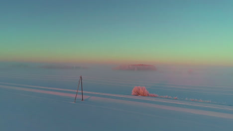 Cinematic-shot-of-fresh-snow-covered-vast-landscape-during-sunrise,-Aerial-shot