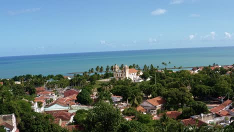 Dolly-in-Luftdrohnenaufnahme-Nähert-Sich-Der-Wunderschönen-Historischen-Kirche-Von-Carmo-Im-Zentrum-Der-Tropischen-Küstenstadt-Olinda-In-Pernambuco,-Brasilien,-Umgeben-Von-Wohnhäusern-Und-Palmen