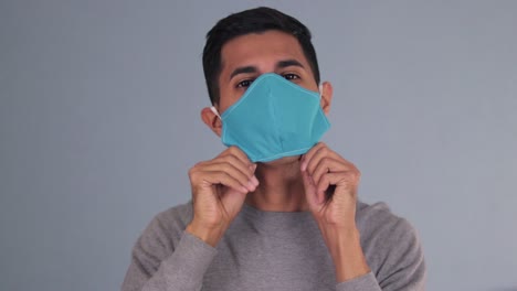 Handsome-latin-man-putting-on-the-face-mask