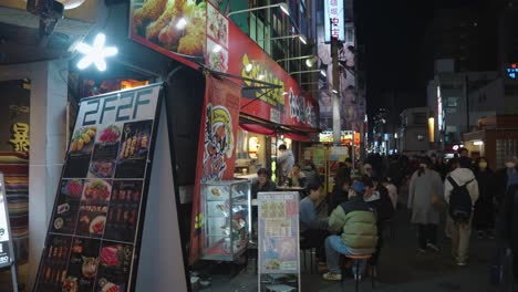 Calles-De-Comida-Callejera-De-Osaka,-Gente-Por-La-Noche-Disfrutando-De-La-Cocina-De-Japón