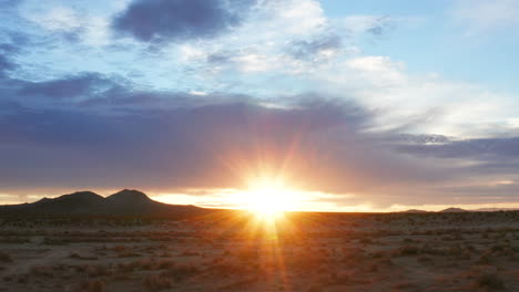 Die-Sonne-Flackert-über-Dem-Horizont,-Während-Die-Morgendämmerung-In-Das-Trockene-Gelände-Der-Mojave-wüste-Eindringt---Gleitender-Aus-Der-Luft