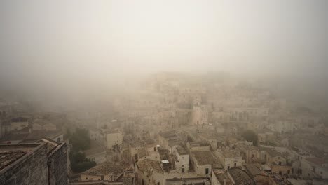 Slow-pan-shot-to-the-right-of-the-old-city-of-Matera-covered-in-mist-in-4k