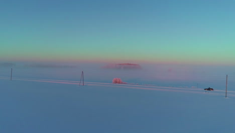 Powerlines,-road-and-endless-agriculture-fields-covered-in-deep-fog,-aerial-view