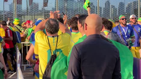 People-in-the-queue-are-fan-of-brazil-football-team-in-world-cup-qatar-2022-to-enter-metro-station-with-lots-of-joy-happiness-sing-song-chanting-football-team-with-yellow-green-flag-and-t-shirt-jersey