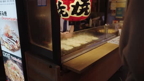 Takoyaki-Street-Food-Verkäufer,-Der-Essen-Für-Reisende-In-Shinsaibashi-Zubereitet