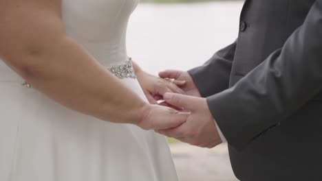 Close-up,-anonymous-heterosexual-plus-sized-couple-holding-hands-on-wedding-day,-slow-motion